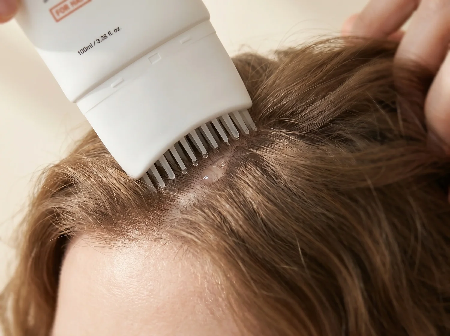Brosse applicatrice Kavira appliquée sur le cuir chevelu